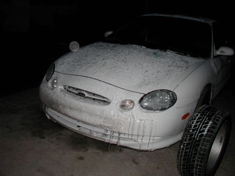 1997 Ford Taurus - This 1997 Ford Taurus is covered in ice, suggesting it has been exposed to freezing conditions. A spare tire sits beside the vehicle.