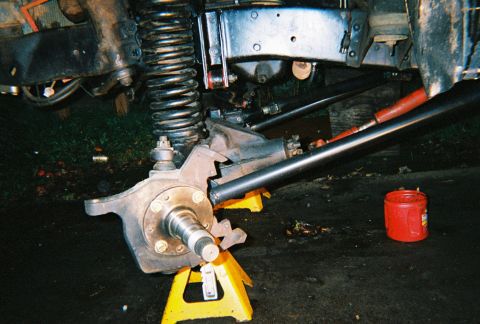 1978 Ford Bronco - The vehicle's front suspension and steering components are visible, supported by yellow jack stands.
