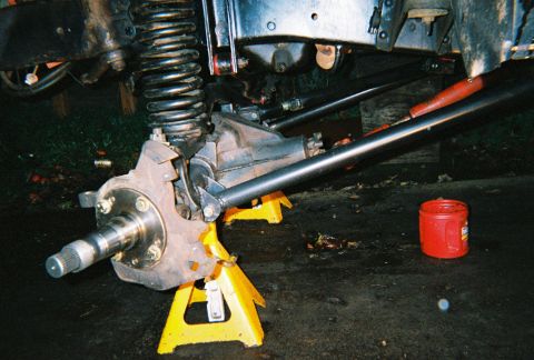 1978 Ford Bronco - Close-up of a vehicle's suspension and axle components, supported by jack stands.