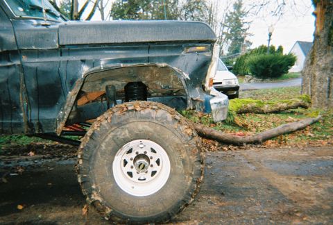 1978 Ford Bronco - Front fender and tire of a 1978 Ford Bronco, showing damage and off-road modifications.