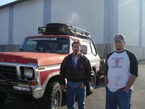 1993 Ford Bronco - Two men stand next to a red and white Ford Bronco with a roof rack.