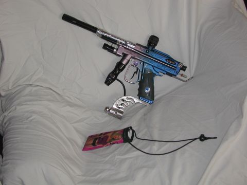 1985 Ford Bronco - A paintball gun with custom coloring and chrome accents is displayed on a white, textured surface.