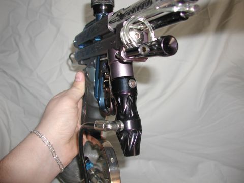 1985 Ford Bronco - A person's hand grips a paintball gun, which has a large capacity magazine attached.