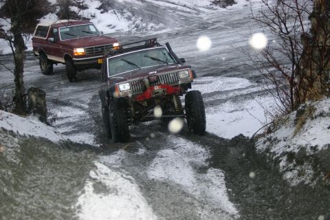 2003 Jeep TJ - Two modified 4x4s navigate a challenging off-road path in winter conditions.