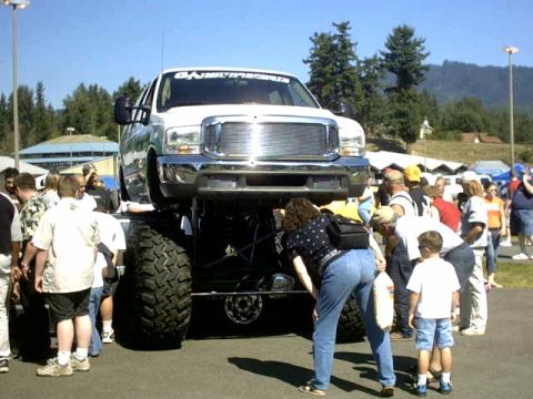 1995 Ford Bronco - A heavily modified pickup truck is on display, drawing a crowd of onlookers.