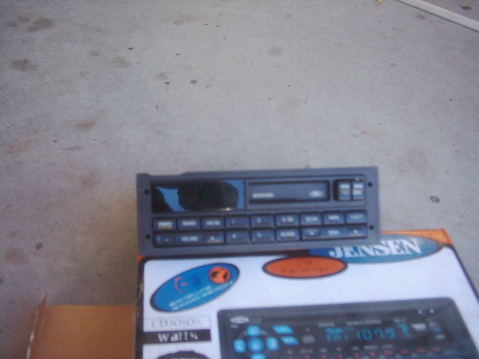 Car stereo unit on top of a box with Jensen branding. Another stereo is visible on the box
