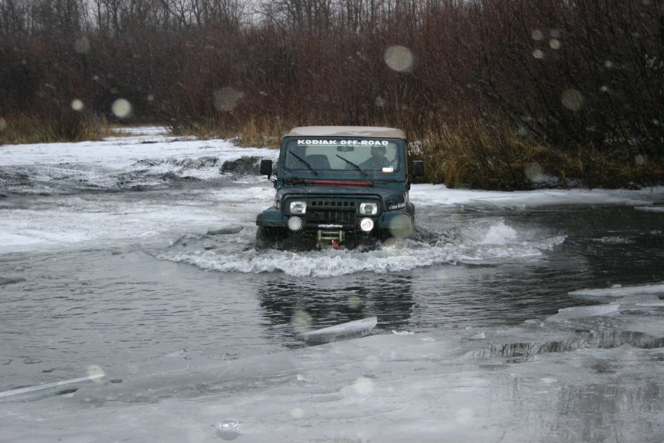 Green Jeep TJ driving through icy water. "KODIAK OFF-ROAD" sticker on windshield