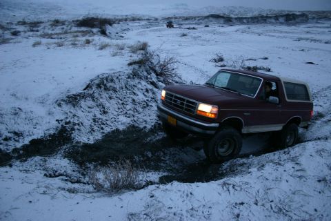 2003 Jeep TJ - Ford Bronco navigating difficult terrain in a snowy landscape.