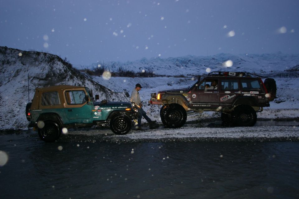 Green Jeep CJ-7 and a brown Jeep Cherokee XJ in snow, side view