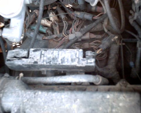 1990 Ford Bronco - Close-up view of a vehicle's engine bay, focusing on the fuse box and complex wiring harness.