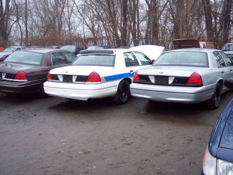 1991 Ford LTD Crown Victoria - Rear view of three Ford Crown Victorias parked outdoors in a lot.