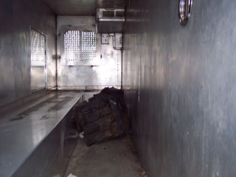 1991 Ford LTD Crown Victoria - View inside a cargo van or truck, showing a large tire and metal shelving.