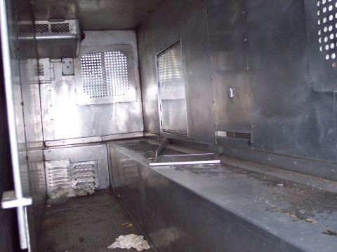 1991 Ford LTD Crown Victoria - The interior of a prisoner transport vehicle, metal construction and basic amenities.