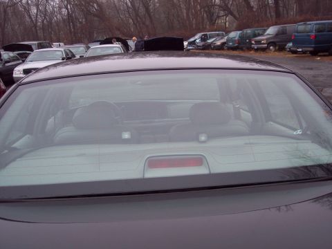 1991 Ford LTD Crown Victoria - Rear interior of a 1991 Ford Crown Victoria LTD, seen through the back window. Other vehicles are parked in the lot.