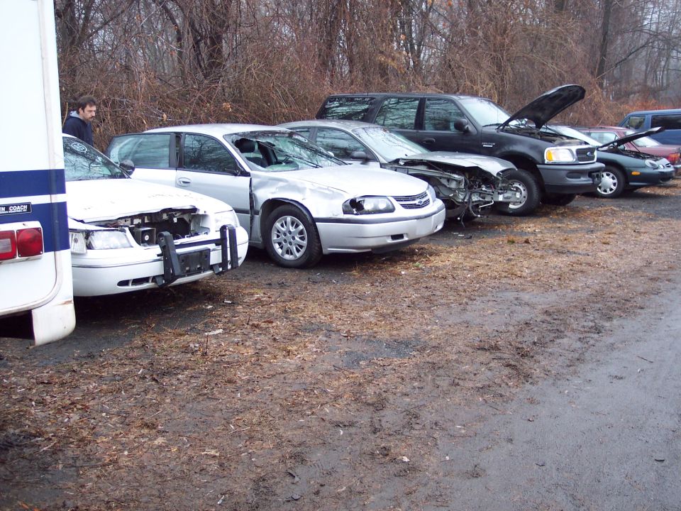 White 1991 Ford Crown Victoria LTD police car, front view, damaged hood and grille