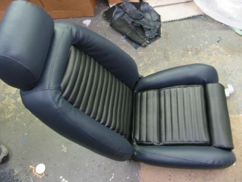 1987 Ford Thunderbird - A dark blue car seat with ribbed upholstery and a headrest is shown, likely for a classic vehicle.