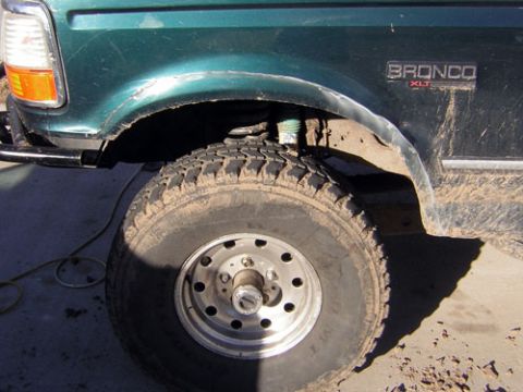 1995 Ford Bronco - Close-up of the front fender, wheel, and suspension of a 1995 Ford Bronco XLT.