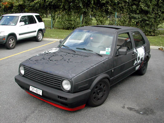 Black hatchback with skull graphics on hood and side, red front lip, black wheels