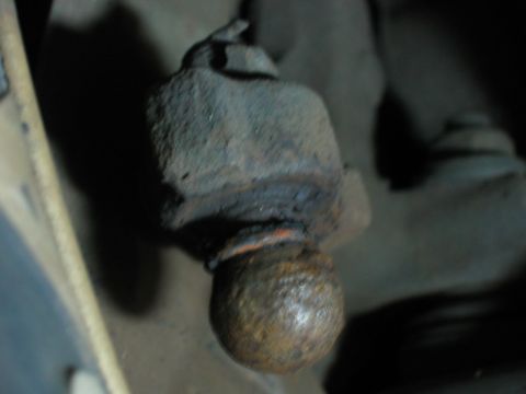 1985 Ford LTD Crown Victoria - A close-up view of a heavily rusted ball joint, showing significant wear and corrosion.