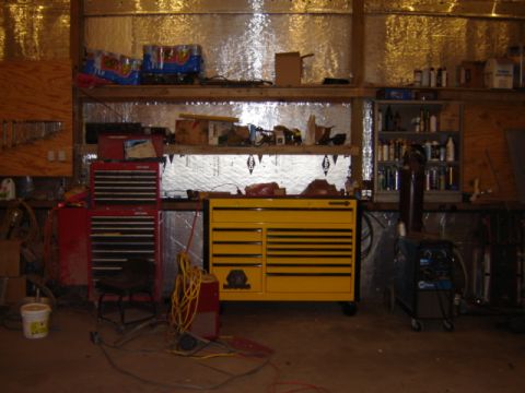1992 Ford Bronco - A workshop scene tool chests, a welding machine, and storage shelves filled with various items.