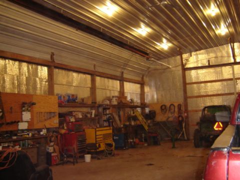 1992 Ford Bronco - A cluttered workshop scene contains various tools, a green tractor, and the front of a red vehicle.
