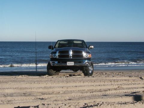 2004 Dodge 2500 - Front view of a 2004 Dodge 2500 on the beach, with a fishing rod nearby.
