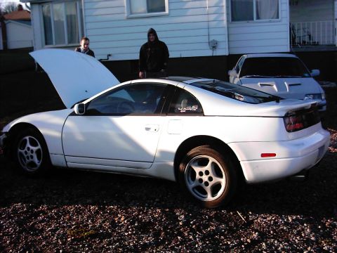 1988 Ford LTD Crown Victoria - White Nissan 300ZX (Z32) T-top coupe sitting on a gravel driveway beside a white house with its hood propped open and the front bumper cove…