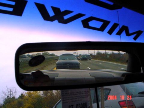 2004 Ford Taurus - A black 2004 Ford Taurus is seen from the driver's perspective on a highway, with other vehicles in the distance.