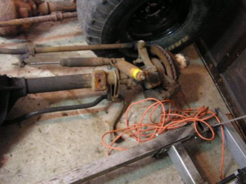 1988 Ford Bronco - Close-up of a vehicle's front axle assembly, showing suspension and braking components.