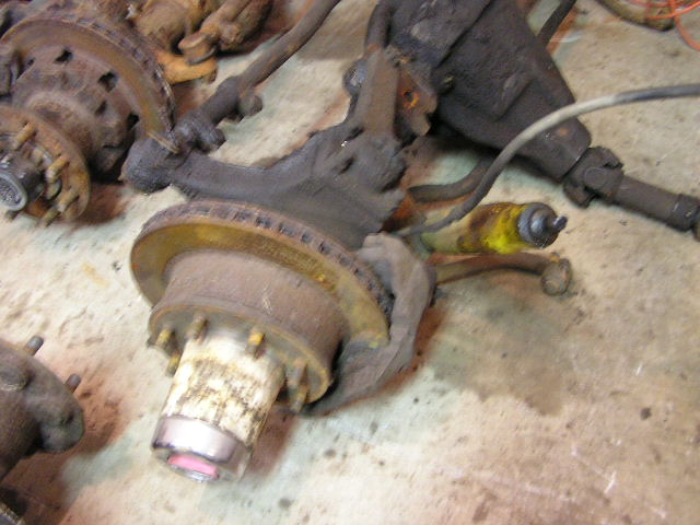 Rusty Dana 60 axle hub and brake rotor assembly with yellow shock absorber
