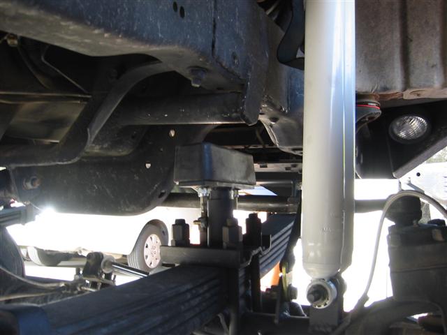 Truck leaf-spring suspension with shackle and white shock under the frame
