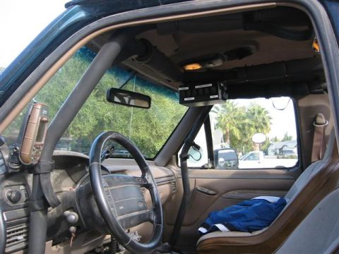 1994 Ford Bronco - The interior of a 1994 Ford Bronco features a roll cage and a panel of auxiliary switches above the windshield.