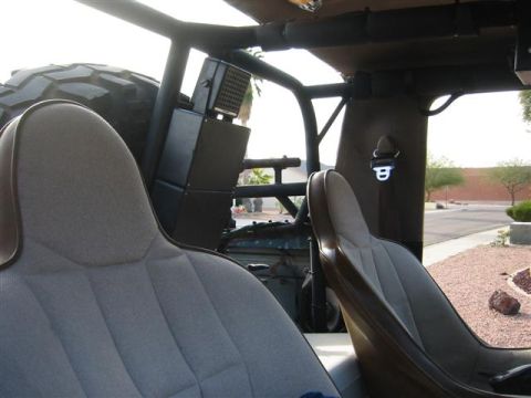 1994 Ford Bronco - The interior of an off-road vehicle is shown, custom seats and a roll cage structure.