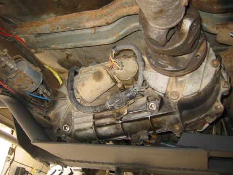 1994 Ford Bronco - Underside view of a vehicle's transfer case and driveshaft assembly, showing mechanical components and wiring.