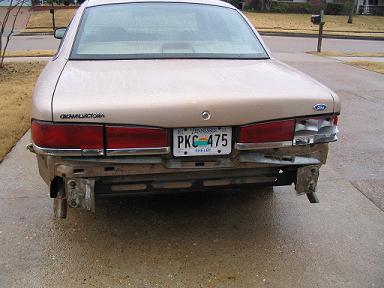 1999 Ford Crown Victoria - Rear view of a 1999 Ford Crown Victoria showing damage to the bumper area.