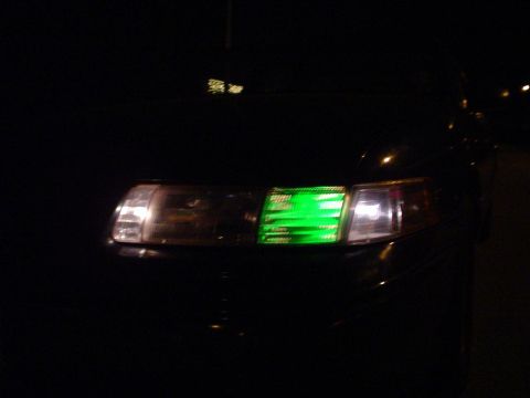 1993 Ford Taurus - The front headlight of a 1993 Ford Taurus features a green digital display.