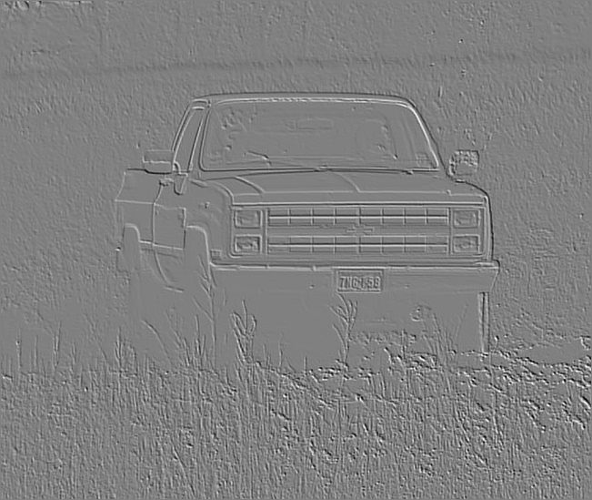Front view of a 1980s Chevrolet pickup truck parked in tall grass. License plate reads "7MC-658"