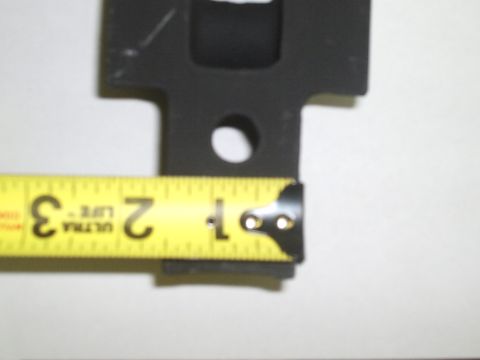 1996 Ford Bronco - A black metal part is shown with a yellow tape measure indicating its dimensions, suggesting it is a vehicle component.