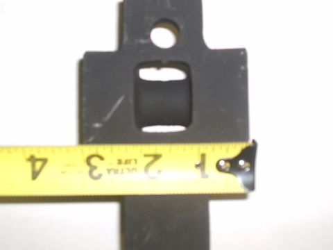 1996 Ford Bronco - A yellow tape measure is used to measure a black metal shackle mount.