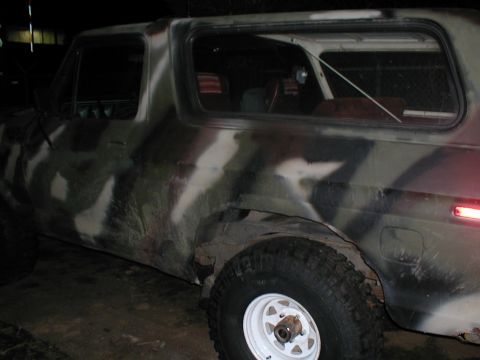 1979 Ford Bronco - This SUV has a camouflage paint job and appears to be in a dimly lit garage or workshop.