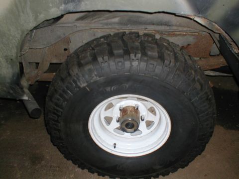 1979 Ford Bronco - Close-up of a vehicle's tire and wheel well, revealing signs of wear and corrosion.