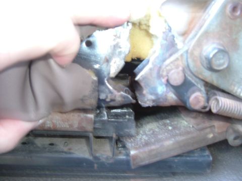 1993 Ford Bronco - A damaged seat mechanism shows exposed foam and rusty metal components, indicating wear and tear.