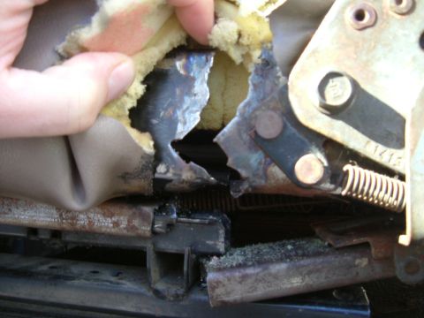 1993 Ford Bronco - Close-up view of damaged seat upholstery and exposed metal frame, showing wear and tear.