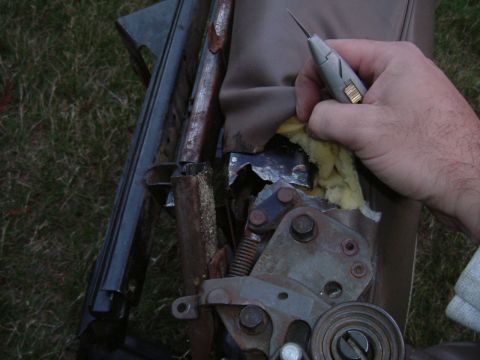 1993 Ford Bronco - A damaged seat mechanism is revealed, showing exposed foam and torn upholstery.