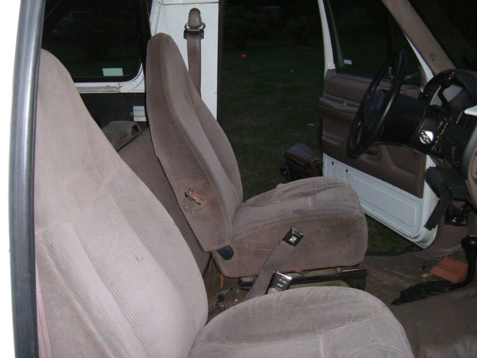 Truck interior with tan cloth bucket seats, open driver's door and tan door panel