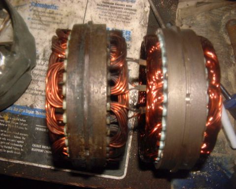1985 Ford F-150 - Close-up view of two automotive alternator rotors, their copper windings and central metal cores.