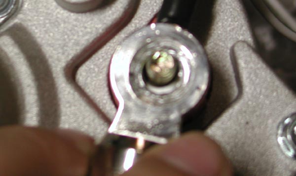 Ring terminal on bolt attached to metal engine part with black wire
