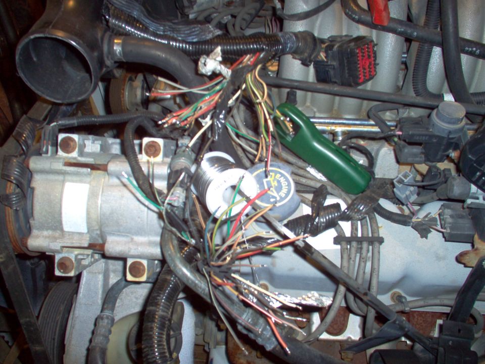 Engine bay with intake removed exposing tangle of multicolored wires across the V8 valve covers