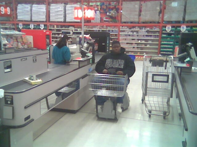 Person in motorized shopping cart at checkout lane in a store