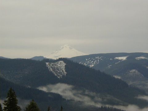 1994 Ford Explorer - A vast mountain landscape under a cloudy sky, with snow on the peaks and trees below.